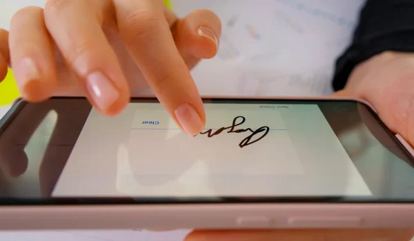 firma-digital-macro-en-la-pantalla-del-telefono-inteligente-con-el-dedo.webp